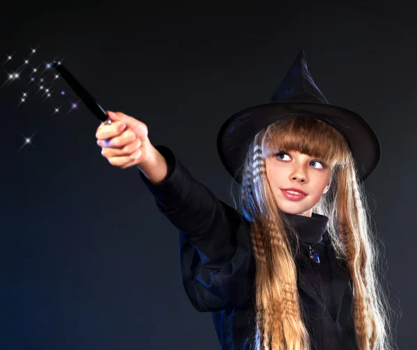 Čarodějnice dívka s kouzelnou hůlkou casting kouzla. — Stock fotografie