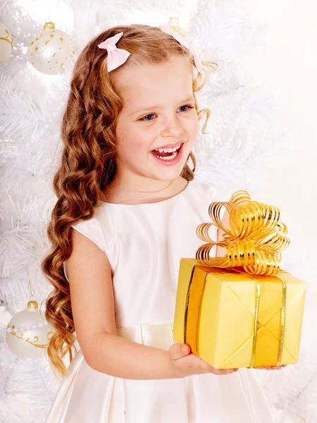 Child with gift box near white Christmas tree. — Stock Photo, Image