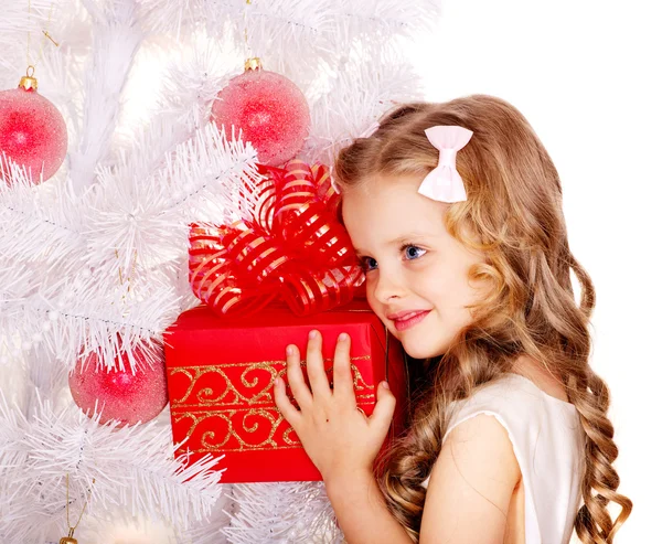 Criança com caixa de presente perto da árvore de Natal branca . — Fotografia de Stock