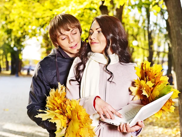 Pareja sosteniendo portátil blanco al aire libre . — Foto de Stock