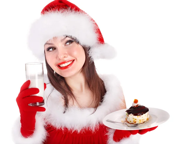 Mädchen mit rotem Weihnachtsmann-Hut isst Kuchen auf Teller. — Stockfoto