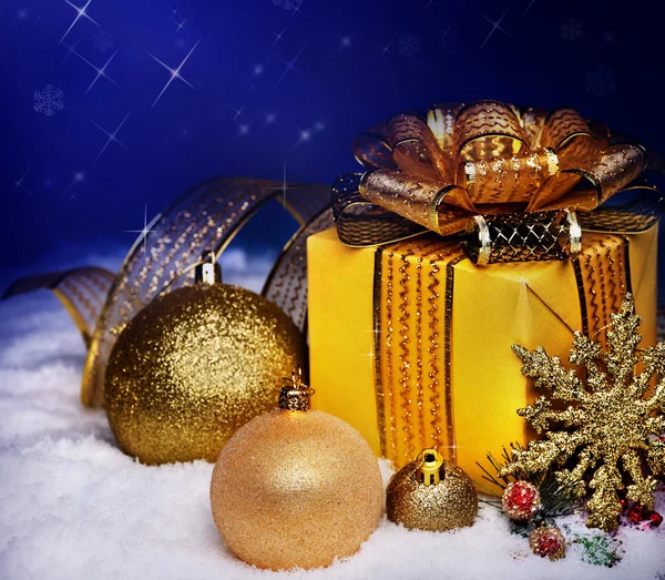 Boule de Noël et boîte cadeau dans la neige . — Photo