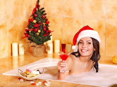 Woman in santa hat relax in bath. clipart
