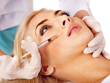 Doctor woman giving botox injections.