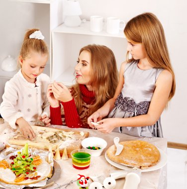 Anne ve çocuk mutfakta hamuru haddeleme.