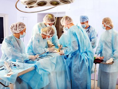 Surgeon at work in operating room. clipart