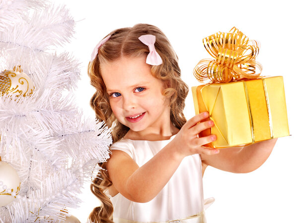 Child with gift box near white Christmas tree.