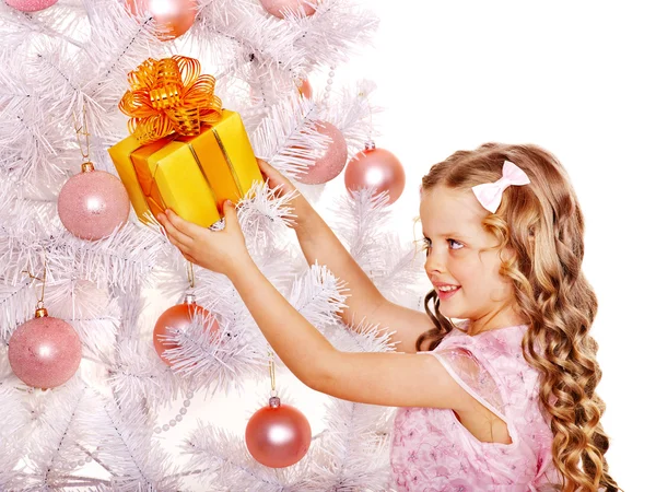 Child with gift box near white Christmas tree. Royalty Free Stock Images