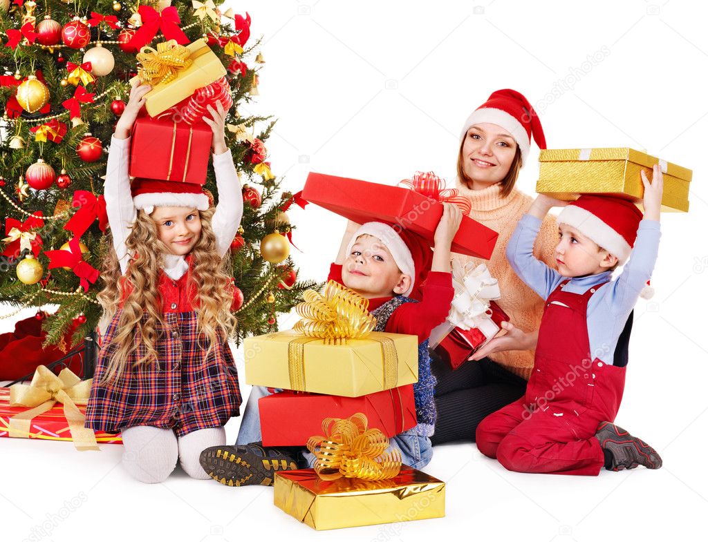 Family with children open gift box near Christmas tree.