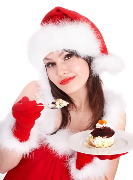 Weihnachtsmädchen in roter Weihnachtsmütze isst Kuchen auf Teller. — Stockfoto