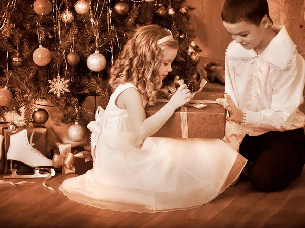 Kinder bekommen Geschenke unterm Weihnachtsbaum. — Stockfoto