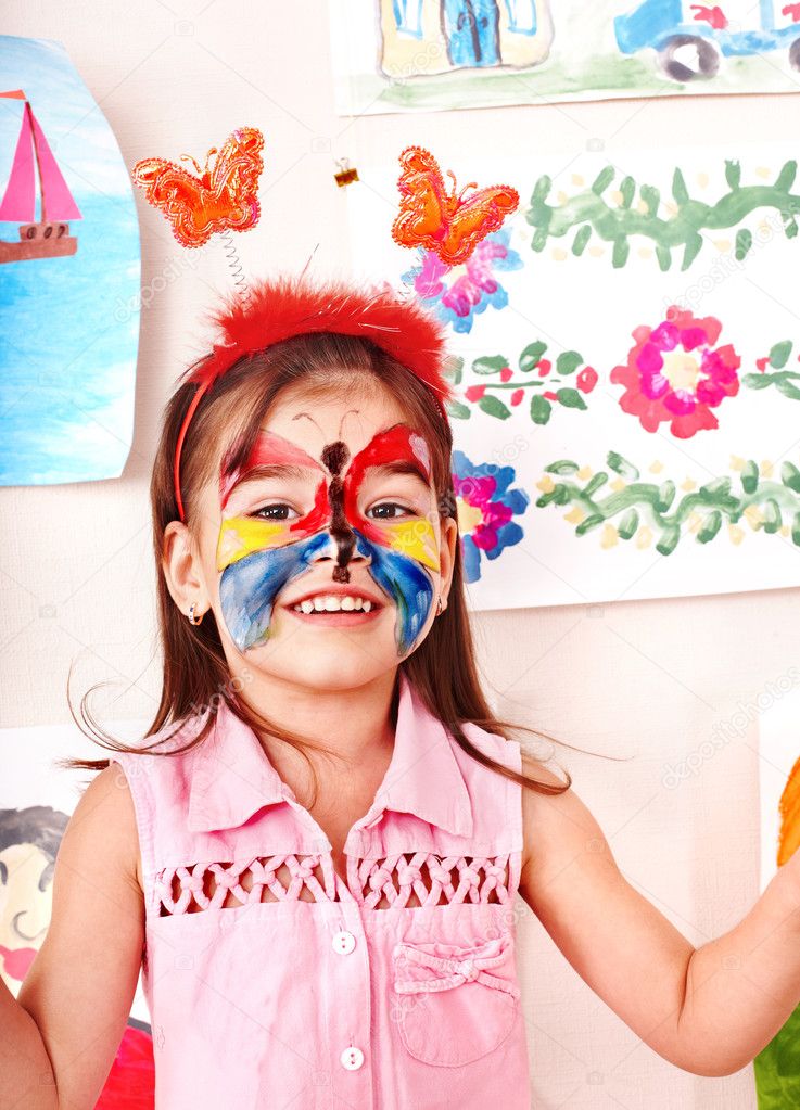 Child with face painting in play room.