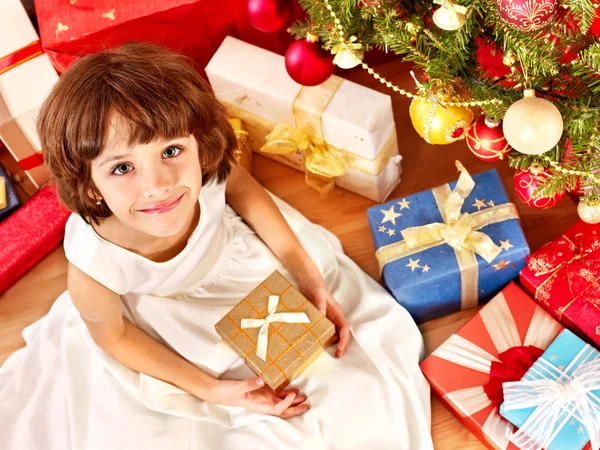 Criança com caixa de presente perto da árvore de Natal . — Fotografia de Stock