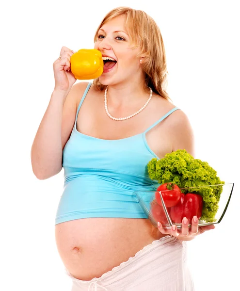 Gravid kvinna äta grönsaker. Stockfoto