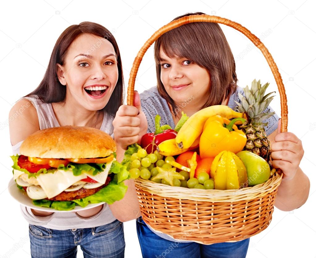 Women choosing between fruit and hamburger.