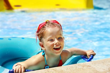 şişme halkada oturan çocuk.