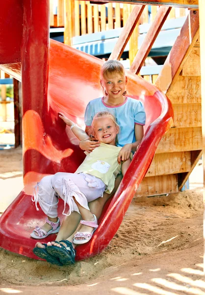 Kinderen verhuizen te glijden in Speeltuin. — Stockfoto