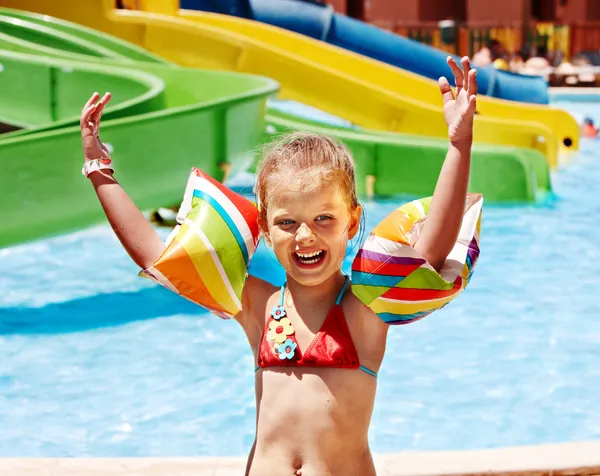 Criança com braçadeiras brincando na piscina . — Fotografia de Stock
