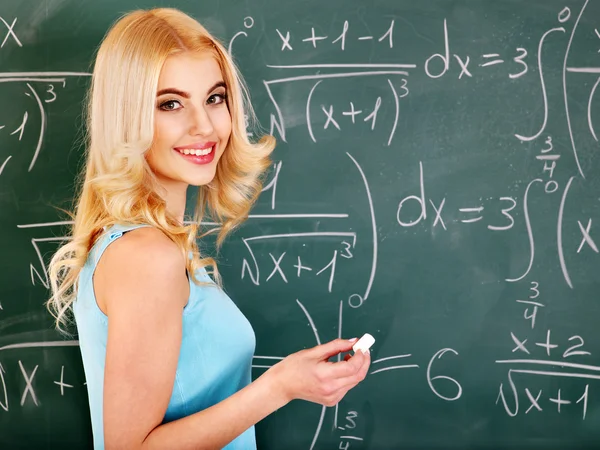 Schoolchild writing on blackboard. — Stock Photo, Image