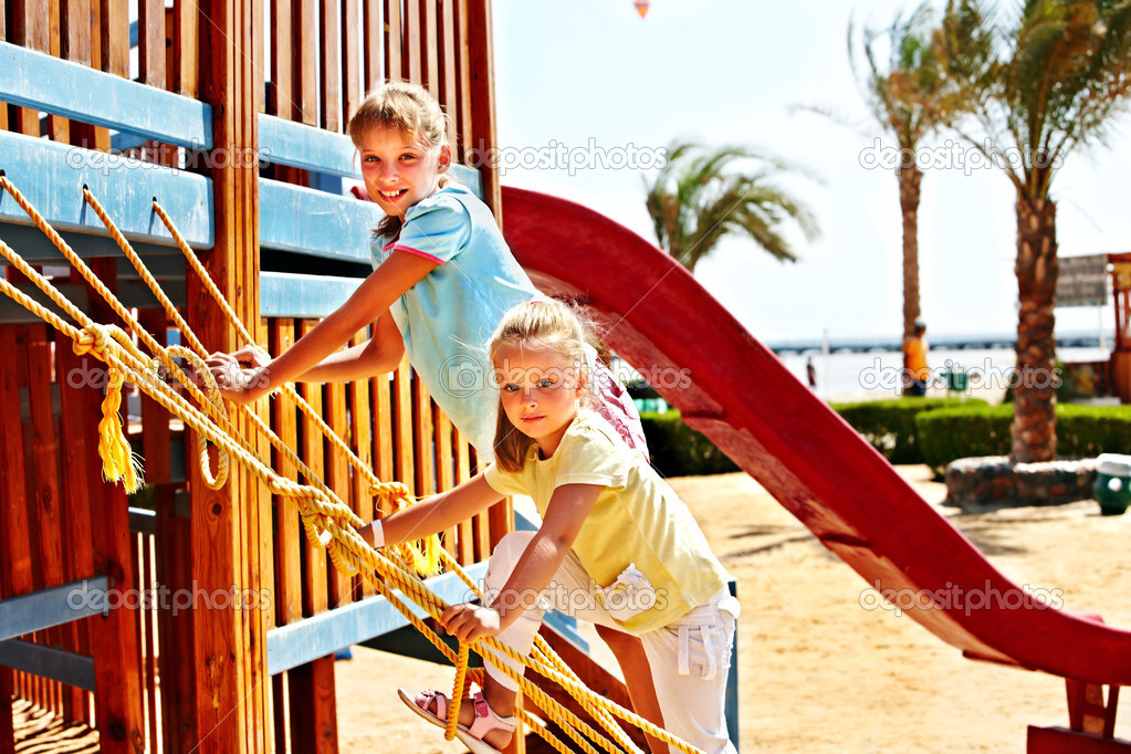 Children move out to slide in playground.