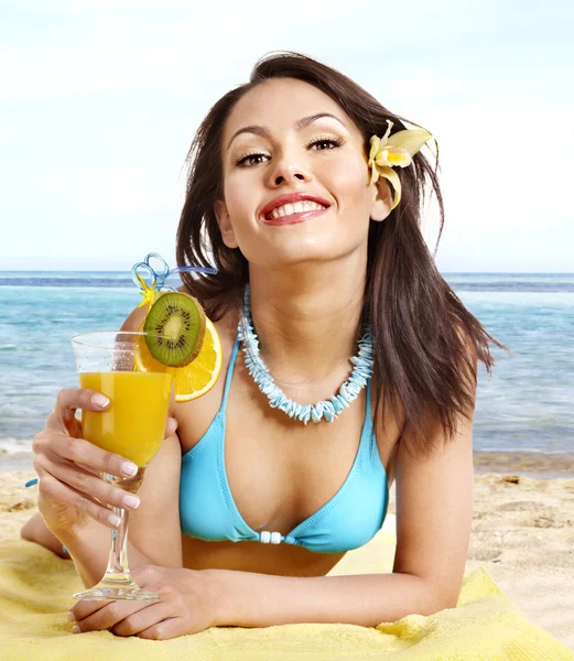 Mädchen im Bikini trinken Saft durch einen Strohhalm. — Stockfoto