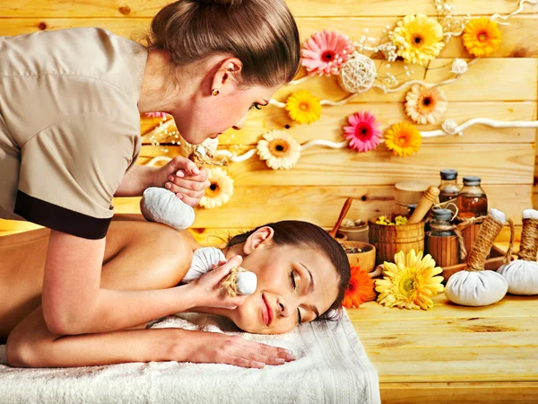 Mujer recibiendo masaje de bola de hierbas . —  Fotos de Stock