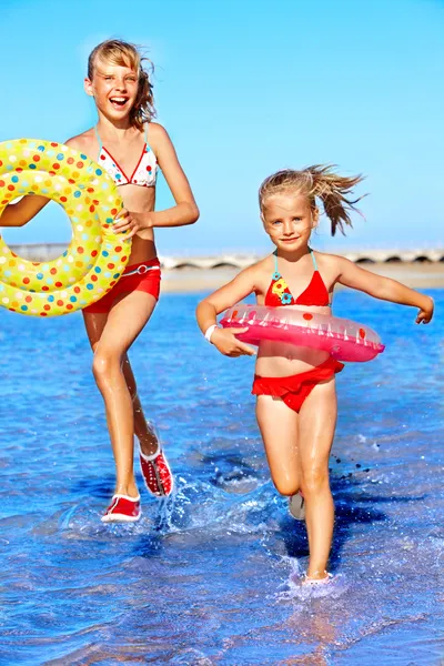 Children holding hands running on beach. — Stock Photo, Image