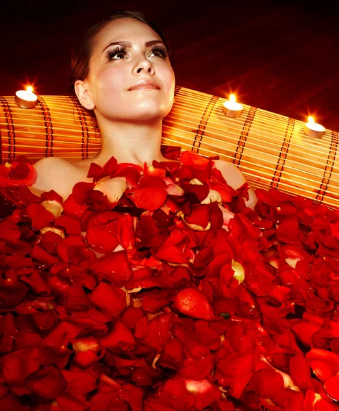 Beautiful girl in jacuzzi with rose petal and candle. — Stock Photo, Image