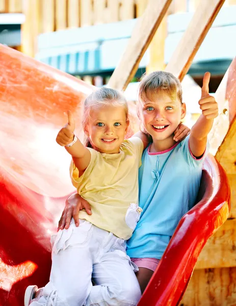 Children move out to slide in playground. — Stock Photo, Image