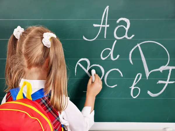 Schulkind schreibt an Tafel — Stockfoto