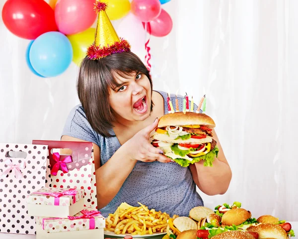 Eszik hamburgert születésnapi nő. — Stock Fotó