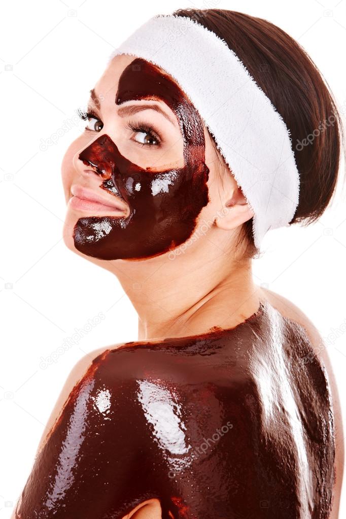 Young woman having chocolate facial mask.