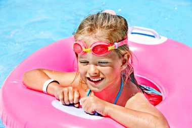 şişme halkada oturan çocuk.