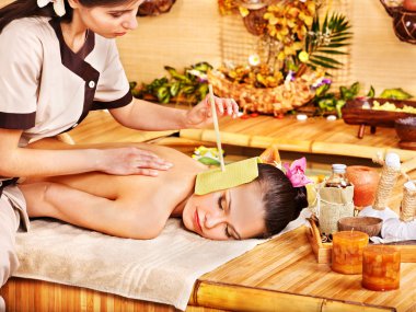 Woman getting massage with ear candle . clipart