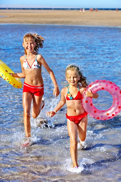 Children holding hands running on beach. — Stock Photo, Image