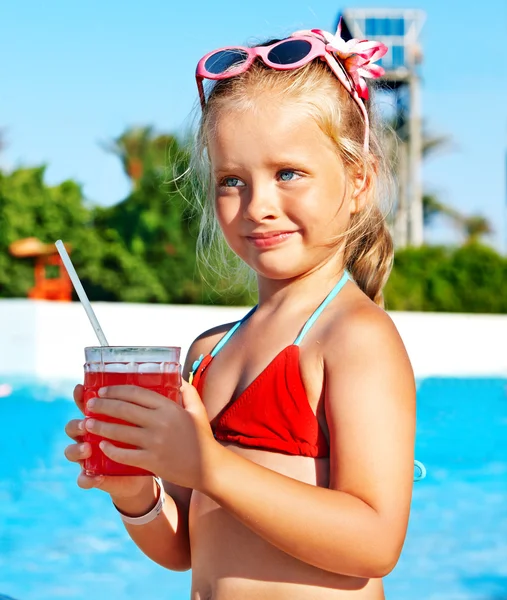 Child drinking near swimming pool. — Stock Photo, Image