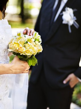 Gelin ve damat çiçek açık tutarak.