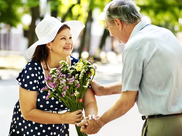 Gelukkige oude paar met bloem. — Stockfoto