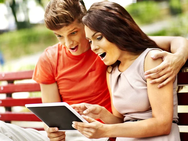 Couple avec tablette PC assis sur le banc  . — Photo