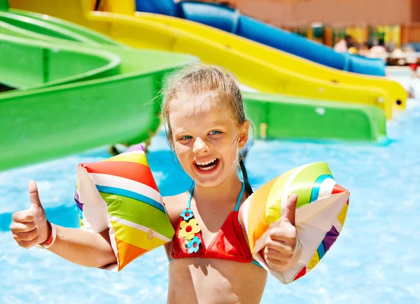 Criança com braçadeiras brincando na piscina . — Fotografia de Stock