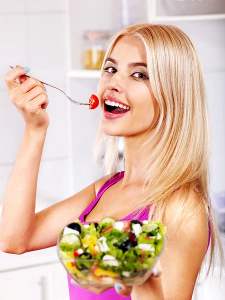 Γυναίκα τρώει σαλάτα στην κουζίνα. — Φωτογραφία Αρχείου