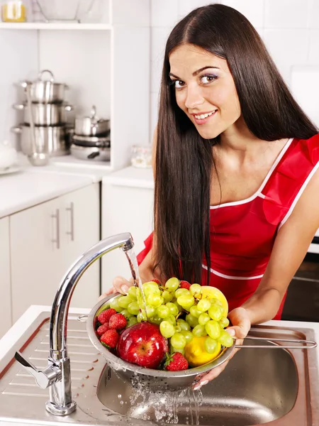 Mulher lavando frutas na cozinha . — Fotografia de Stock