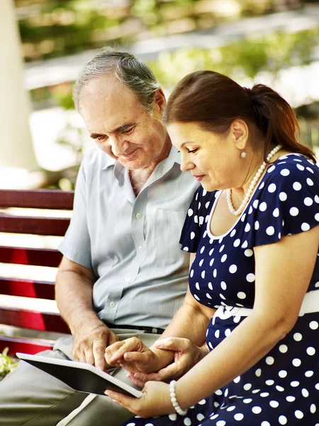 Casal de idosos com tablet pc sentar no banco  . — Fotografia de Stock