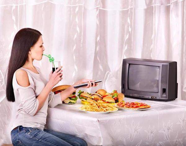 Жінка їсть фастфуд і дивиться телевізор . — стокове фото