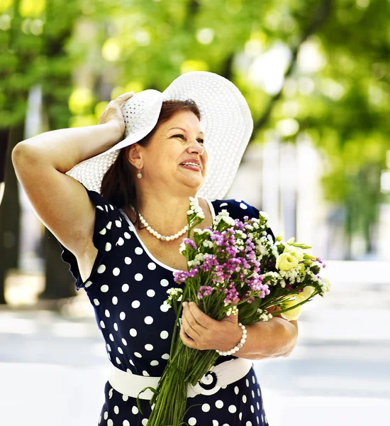 Szczęśliwa kobieta starszy z kwiatem. — Zdjęcie stockowe