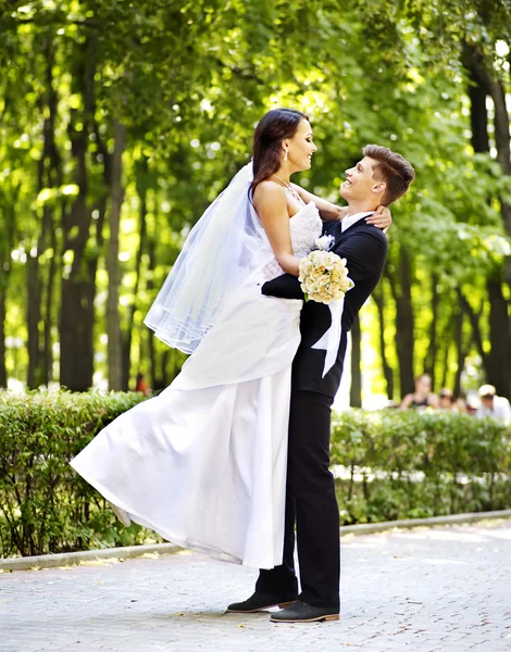 Bride and groom with flower outdoor. — Stock Photo, Image