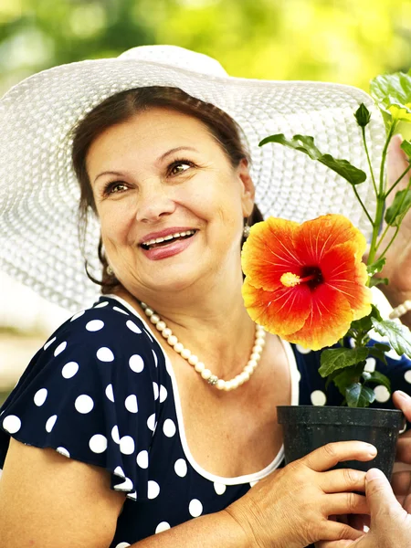 Feliz mujer mayor con flor . — Foto de Stock