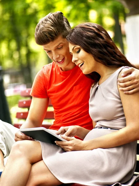 Couple avec tablette PC assis sur le banc  . — Photo