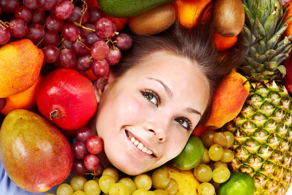 Meisje in groep van fruit. — Stockfoto