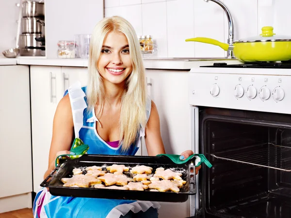 Девочка печет печенье в духовке — стоковое фото